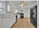 A kitchen features white cabinets, countertops, wood-look flooring, black appliances, and a refrigerator at 397 Oslo Dr, Deltona, FL 32725