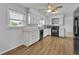 A kitchen features white cabinets, countertops, wood-look flooring, and black appliances at 397 Oslo Dr, Deltona, FL 32725