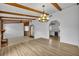 Open concept living room featuring hardwood floors, exposed beams, and views into the kitchen at 397 Oslo Dr, Deltona, FL 32725
