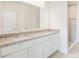 Bright bathroom featuring a double vanity with granite countertop, white cabinets, and a tiled shower at 4152 Sagefield Dr, Harmony, FL 34773