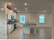 Spacious kitchen featuring white cabinets, granite countertops, a center island, and stainless appliances at 4152 Sagefield Dr, Harmony, FL 34773