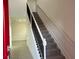 Carpeted staircase with a black metal railing and white trim, ascending from the tiled entryway of the home at 4152 Sagefield Dr, Harmony, FL 34773