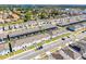 An aerial view that showcases townhouses with screened in lanais, landscaped yards and solar panels near a scenic lake at 4210 Lana Ave, Davenport, FL 33897