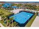 Aerial shot of blue basketball court surrounded by palm trees and pool with clubhouse in background at 4210 Lana Ave, Davenport, FL 33897