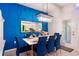 Elegant dining room with a long table set for a meal, a vibrant blue accent wall, and modern lighting at 4210 Lana Ave, Davenport, FL 33897