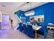 Bright dining area with a long table, blue chairs, a staircase, and a modern chandelier fixture at 4210 Lana Ave, Davenport, FL 33897