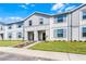 Well-maintained two-story townhome with modern facade, green lawn, and tidy landscaping at 4210 Lana Ave, Davenport, FL 33897