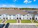 Exterior of townhouse featuring a neatly landscaped front yard, ample parking, and charming architectural details in a sunny setting at 4210 Lana Ave, Davenport, FL 33897