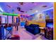 Bright game room with arcade games, a foosball table, muraled walls, and colorful neon lighting at 4210 Lana Ave, Davenport, FL 33897