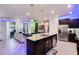 Spacious kitchen island with a sink, dishwasher, and seating, flowing into the living area with outdoor access at 4210 Lana Ave, Davenport, FL 33897