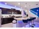 Modern kitchen with dark cabinetry, a spacious island with bar seating, stainless steel appliances, and stylish pendant lighting at 4210 Lana Ave, Davenport, FL 33897