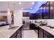 Well-equipped kitchen with granite countertops, dark cabinets, stainless steel appliances, and convenient access to the living area at 4210 Lana Ave, Davenport, FL 33897