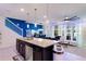 Bright kitchen and living area featuring an island with bar seating, stylish lighting, and a view of the pool area at 4210 Lana Ave, Davenport, FL 33897