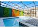 Enclosed pool area with privacy walls, attractive pavers, and partial sun protection in the screen enclosure at 4210 Lana Ave, Davenport, FL 33897