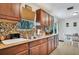 Well-lit kitchen with wooden cabinets, countertop, and a view into the dining area at 4482 Se 142Nd St, Summerfield, FL 34491