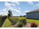 Green backyard with decorative plants, black fence, and a gazebo in the distance at 4672 Marina Row Dr, Orlando, FL 32820