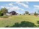 Expansive backyard features a pergola with seating, green lawn, and well-maintained landscaping at 4672 Marina Row Dr, Orlando, FL 32820