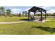 Backyard with water view has lush lawn, a gazebo, and brick walkway for backyard enjoyment at 4672 Marina Row Dr, Orlando, FL 32820
