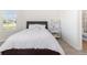 Bright bedroom featuring a queen bed, a white bookcase, and light grey wood-look floors at 4672 Marina Row Dr, Orlando, FL 32820