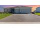 Inviting single-story home with a paved driveway, two-car garage, and well-maintained landscaping at 4672 Marina Row Dr, Orlando, FL 32820