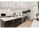 Kitchen island view with seating, pendant lights, and open flow to the living space at 4672 Marina Row Dr, Orlando, FL 32820