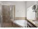 Bright bathroom with a walk-in shower, soaking tub, and a granite-topped vanity at 475 Pitt St, Clermont, FL 34711