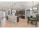 Open-concept kitchen featuring a breakfast bar, modern appliances, dark cabinetry, and stylish tile flooring at 475 Pitt St, Clermont, FL 34711