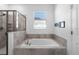 Bright bathroom featuring a soaking tub with tile surround and a glass-enclosed shower at 5052 Blanchard Ct, St Cloud, FL 34772