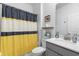 Well-lit bathroom with modern vanity and a shower with a stylish yellow and gray curtain at 5052 Blanchard Ct, St Cloud, FL 34772