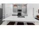 Modern kitchen with gray cabinets, stainless steel appliances, and a large quartz island with seating at 5052 Blanchard Ct, St Cloud, FL 34772