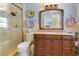 Elegant bathroom with tile shower, wooden vanity, granite countertop and tasteful decor at 5263 Jade Cir, Belle Isle, FL 32812
