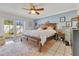 Bright bedroom features French doors, ceiling fan, and a wooden bedframe with drawer storage and an area rug at 5263 Jade Cir, Belle Isle, FL 32812