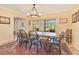 Bright dining room features a large window, a rustic table with decorative chandelier, and terracotta tile flooring at 5263 Jade Cir, Belle Isle, FL 32812