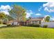 Well-maintained home featuring a brick facade, attached garage, and expansive, manicured lawn at 5263 Jade Cir, Belle Isle, FL 32812