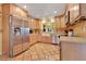 This well-lit kitchen features terracotta floors, stainless steel appliances, wooden cabinets, and a charming farmhouse sink at 5263 Jade Cir, Belle Isle, FL 32812