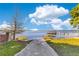 A concrete path leading to a tranquil lake with dock offers serene waterfront access at 5263 Jade Cir, Belle Isle, FL 32812