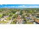 An aerial view of a residential neighborhood nestled among lush trees and greenery, overlooking a serene lake at 5263 Jade Cir, Belle Isle, FL 32812