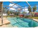 Sparkling screened-in pool with clear water and a basketball hoop on a lush green lawn at 5263 Jade Cir, Belle Isle, FL 32812