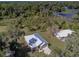 Stunning aerial view of a home with a metal roof surrounded by lush greenery and a manicured lawn at 5694 Aragon Ave, De Leon Springs, FL 32130