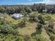 Aerial view of home on a lush lot with mature trees at 5694 Aragon Ave, De Leon Springs, FL 32130