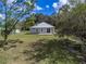 Aerial view of a well-maintained home with a metal roof and spacious backyard at 5694 Aragon Ave, De Leon Springs, FL 32130
