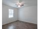 Bright bedroom featuring hardwood floors, ceiling fan, and a window providing natural light at 5694 Aragon Ave, De Leon Springs, FL 32130