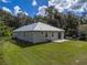 Well-maintained home features a metal roof, tidy lawn and patio area at 5694 Aragon Ave, De Leon Springs, FL 32130