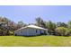 Exterior view of the home shows a spacious backyard and a metal roof at 5694 Aragon Ave, De Leon Springs, FL 32130