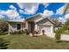 Charming one story home with attached garage, tidy landscaping, and an American flag at 5694 Aragon Ave, De Leon Springs, FL 32130