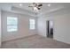 Serene primary bedroom with a tray ceiling, carpet flooring, and natural light at 5694 Aragon Ave, De Leon Springs, FL 32130