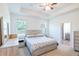 Bright main bedroom with a tray ceiling, neutral decor, and en-suite bathroom at 5694 Aragon Ave, De Leon Springs, FL 32130
