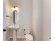 Modern half-bathroom features a pedestal sink, oval mirror, and contemporary lighting at 6525 Rover Way, St Cloud, FL 34771