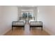 Bright bedroom featuring two twin beds, hardwood floors, and a sunlit window at 6525 Rover Way, St Cloud, FL 34771