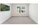Well-lit carpeted room with a mounted TV and bright windows showcasing natural light at 6525 Rover Way, St Cloud, FL 34771